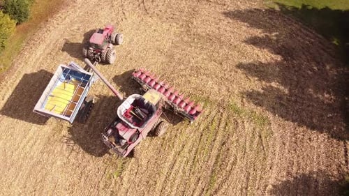 Combine Harvester Harvesting Ripe Corn On Harvest Field In Michigan - aerial drone shot