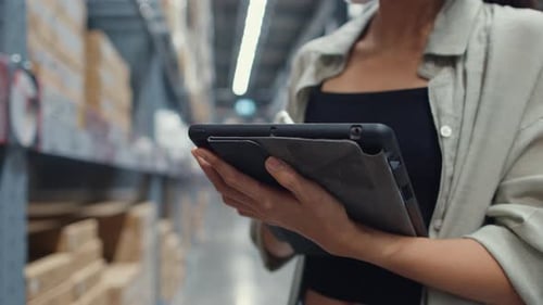 Asian business woman manager using digital tablet checking inventory levels in shopping center