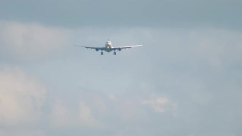 Airplane Flying Towards Camera in Cloudy Sky