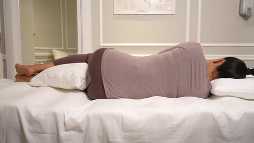 Woman resting comfortably in prone position with pillow
