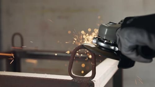 Angle Grinder Smooths Metal Loop in Workshop