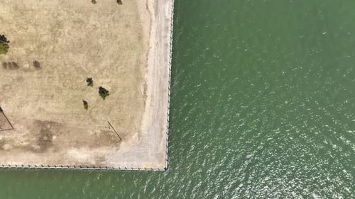 A top down view, directly above the shore of the Great Bay in Bay Shore, NY on a sunny day. The dron