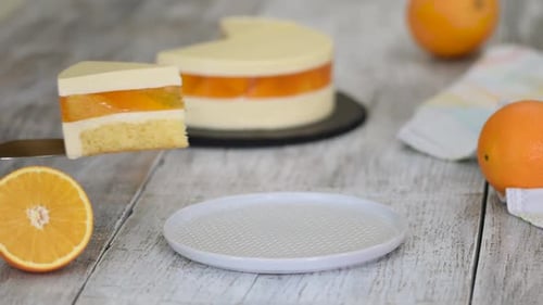 Piece of Orange Mousse Cake with Jelly and Orange Slices