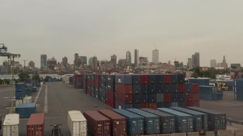 LUFTAUFNAHME: Fliegen über rote und blaue industrielle Frachtcontainer in Docks mit New York City mit