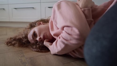 Zoom sur la vidéo d'une jeune femme caucasienne déprimée allongée sur le sol.