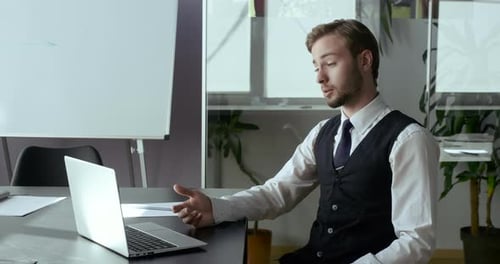 Serious Young Business Man Talking on Video Conference Online in Office. Handsome Worker Having