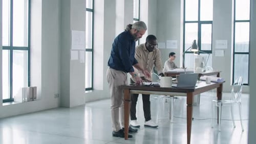 Multiethnic Male Architects Discussing Project in Office