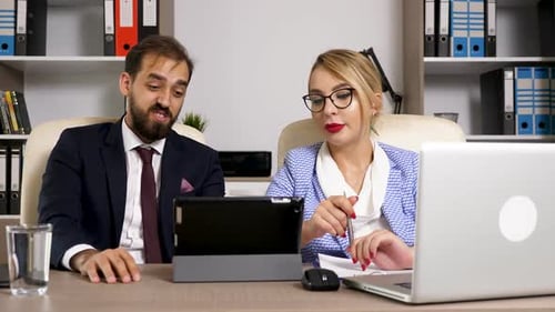 Business Partners in the Office Talking and Looking at Digital Tablet Screen