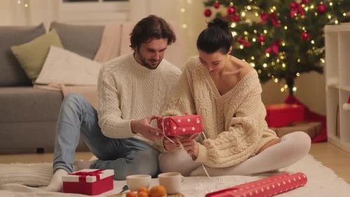 Couple Wrapping Christmas Gifts in Cozy Home