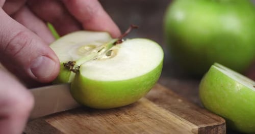 Man schneidet grünen reifen Apfel.