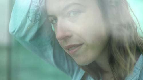 Woman looking through window, portrait