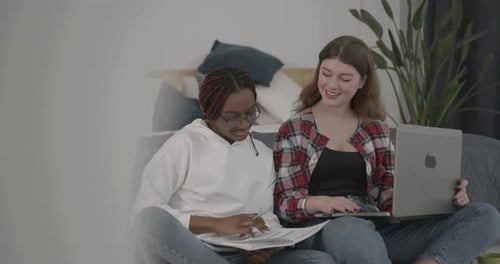 Friends Working Together on Laptop and Notes Indoors
