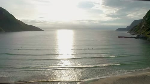 Surfers Riding the waves During Sunset