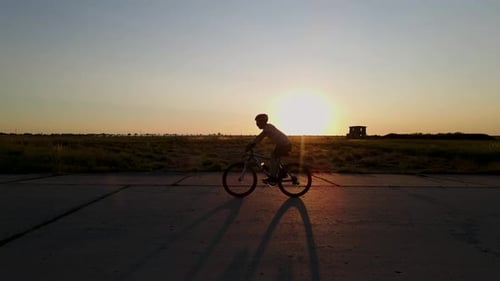 Silhouette eines Mountainbikers bei Sonnenuntergang, Zeitlupe