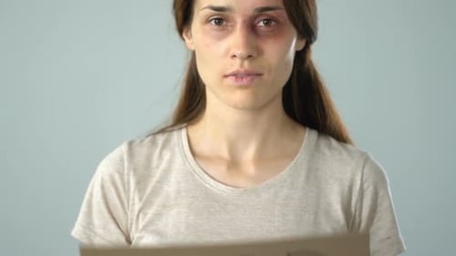 Woman Holding a Stop Sign with Bruises on Face