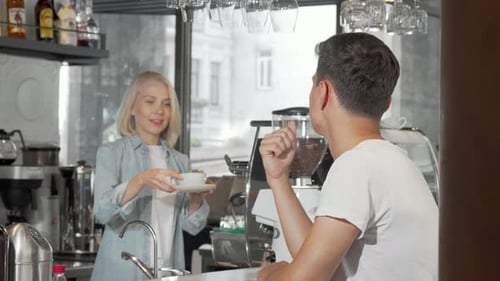 Handsome Young Man Smiling To the Camera While Enjoying His Coffee at the Cafe