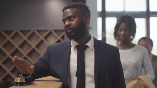 Man Rings Bell at Hotel Reception Desk