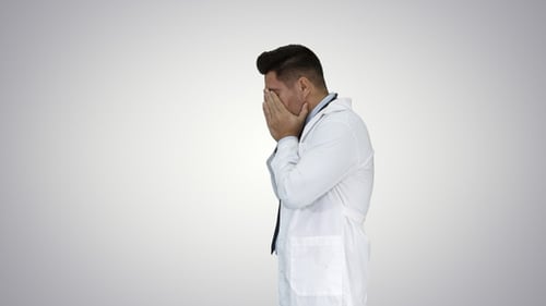 Upset Doctor Rubbing Face While Talking