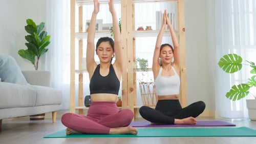 Women Exercising Together Doing Yoga At Home