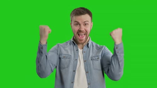 Glücklicher Mann freut sich über Erfolg bei Chroma Key. Bärtiger Mann feiert Sieg