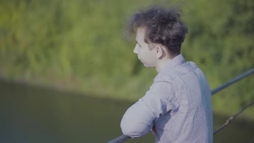 Guy Walks on Suspended Bridge in the Forest