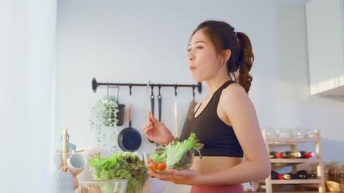 Young Woman Enjoys Healthy Salad in Bright Kitchen
