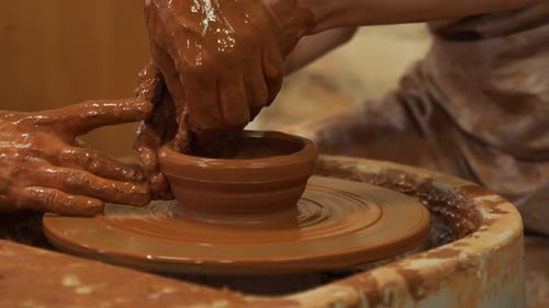 Artist Shaping Clay Bowl on Pottery Wheel