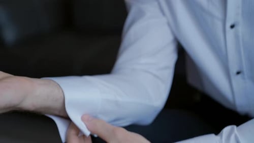 Man Fastening Cufflinks on Dress Shirt Before Wedding