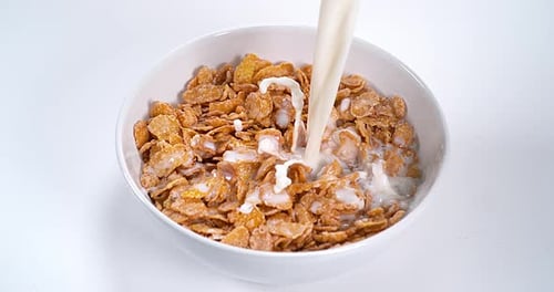Milk Pouring into Cereal Flakes Bowl