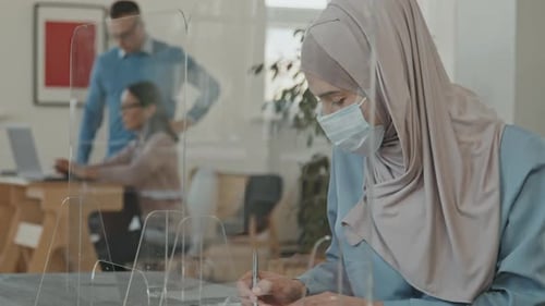 Woman Signs Document in Modern Office Environment