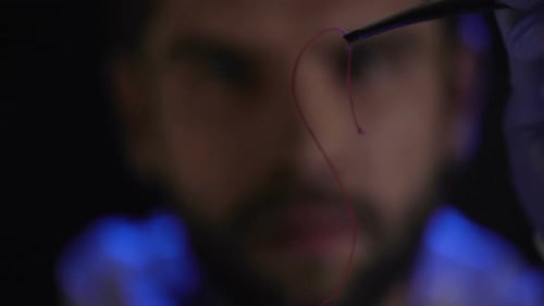 Criminalist Examining a Piece of Thread, Physical Evidence from Place of Crime