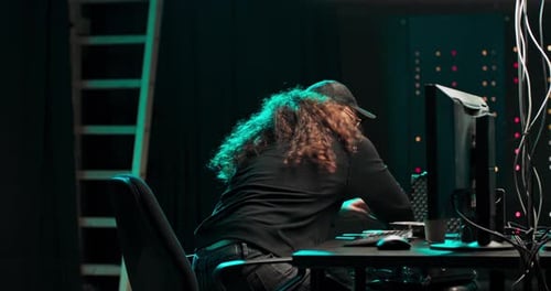 Person Typing at Computer in Dark Office