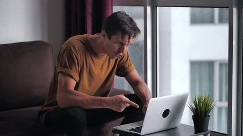Frustrated Man Working at Home on Laptop