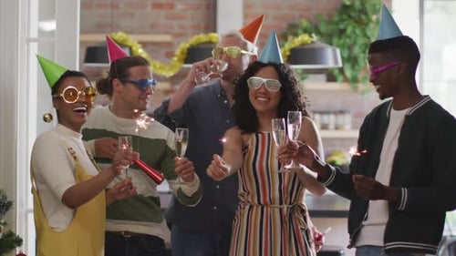 Grupo feliz de diversos amigos em chapéus de festa comemorando juntos, brindando com videira