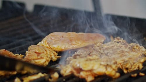 Close up of chicken breast roasted on a grill with flames