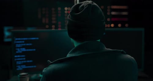 Young Adult Coding in Dark Room at Computer