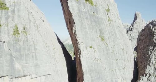 Aerial Flight Above Mountain Top with Pines and Rocks in Sunny Day
