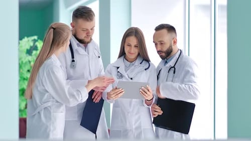 Doctors Collaborate Using Tablet in Hospital Setting