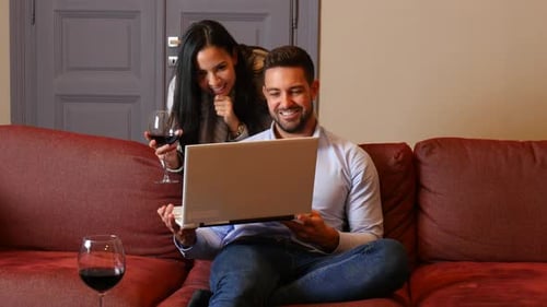 Couple Relaxing with Wine and Laptop at Home