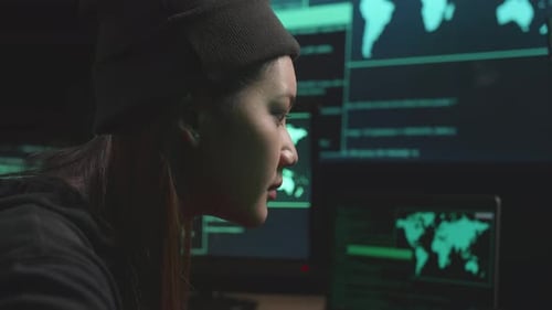 Une hacker asiatique en gros plan utilisant le piratage informatique et le code sur plusieurs écrans d'ordinateur