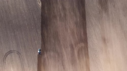 Tractor Plows Ground on Cultivated Farm Field