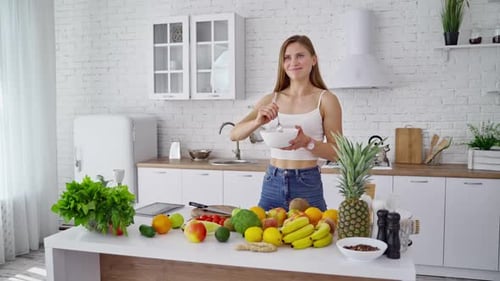 Woman Mixing Salad With Fresh Produce in Kitchen