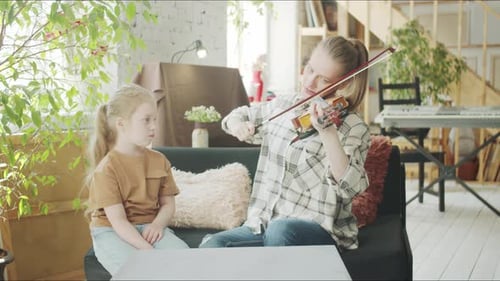 Woman Plays Violin for Little Girl at Home