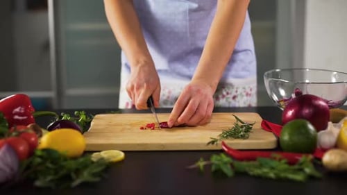 Woman Hands Cutting Chili Pepper in the Kitchen