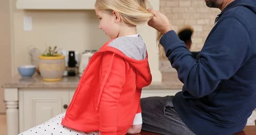 Father Brushing Daughter's Hair in Kitchen