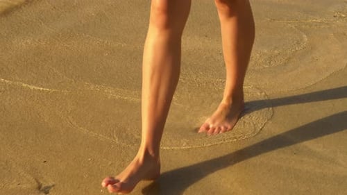 Barefoot Woman Walking Along the Beach
