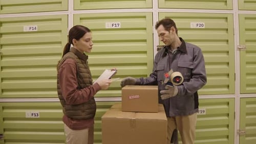 Workers Packing Boxes in Warehouse