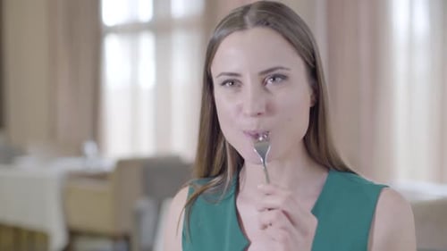 Close-up of Brunette Woman Enjoying Dessert in Restaurant. Portrait of Smiling Young Caucasian Lady