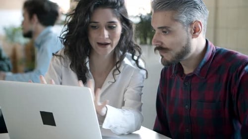Colleagues Collaborate on Laptop in Bright Modern Office