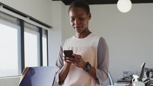 Smiling Woman in Office Using Phone